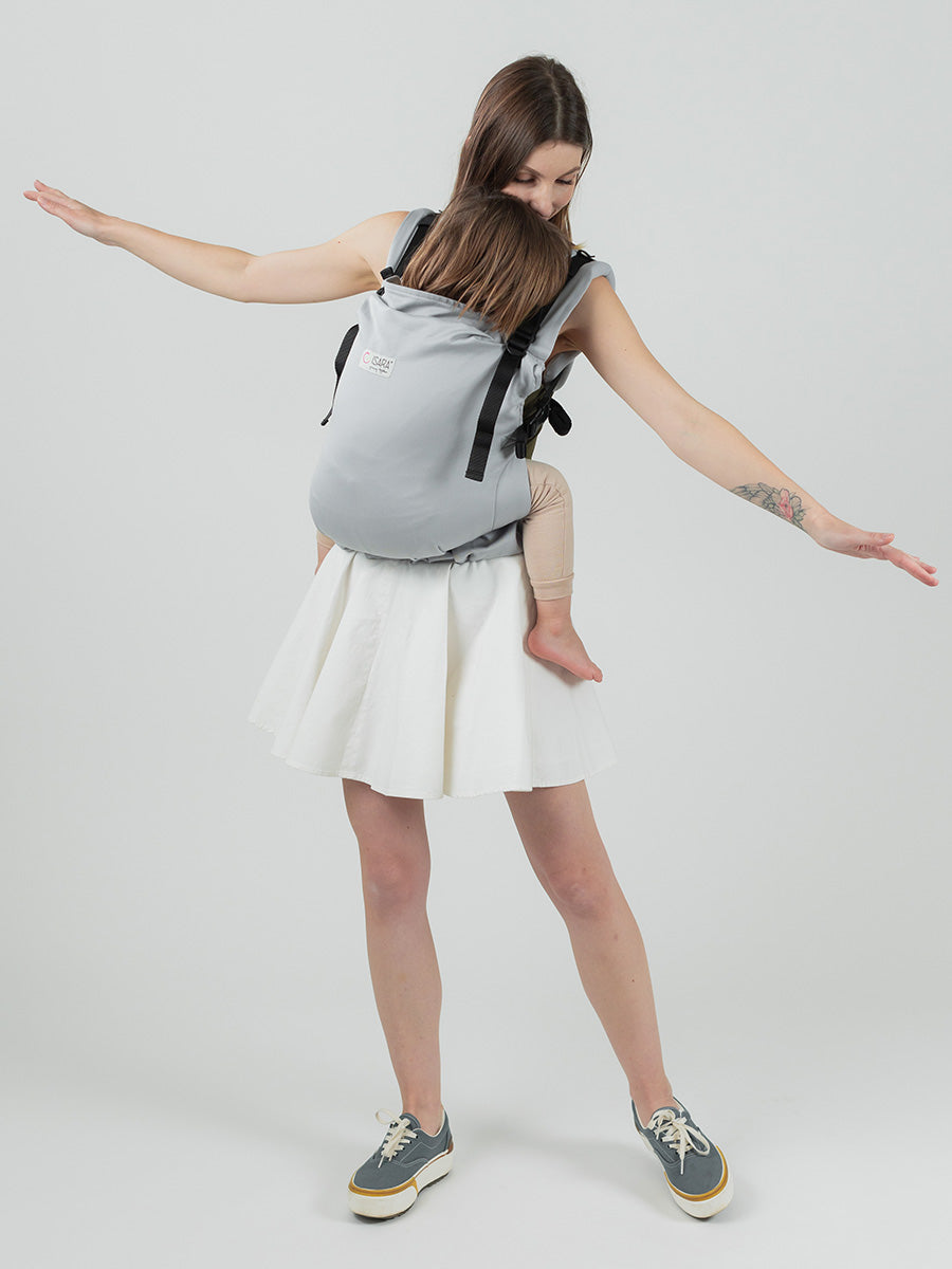 Isara Preschooler - Pearl Grey baby carrier worn by a parent with child, showcasing ergonomic design and versatility | Babymaxi
