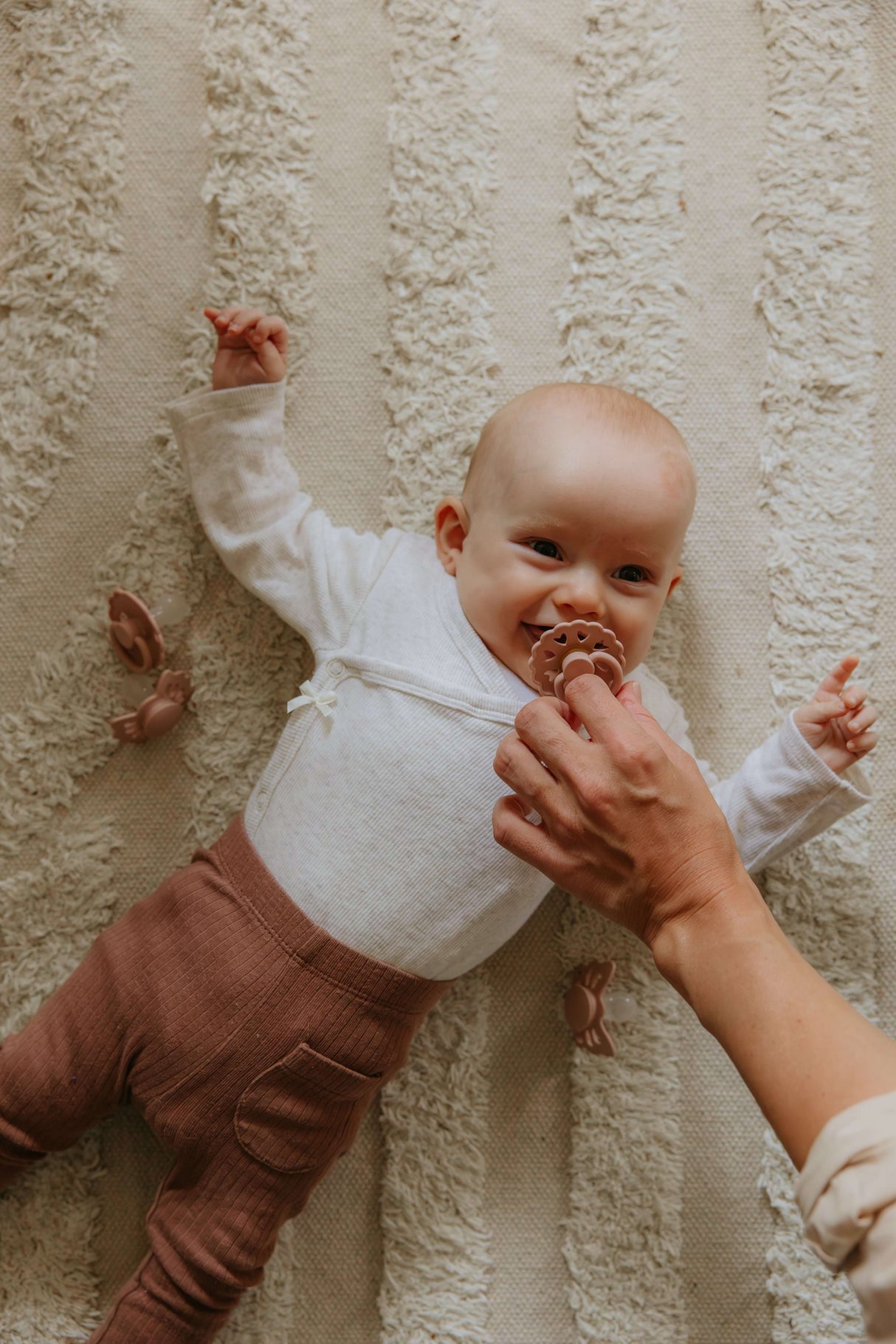 Baby enjoying a 6-Pack Silicone Pacifier Box – Safe, Non-Toxic & Sustainable, with gentle hands holding the pacifier | Babymaxi
