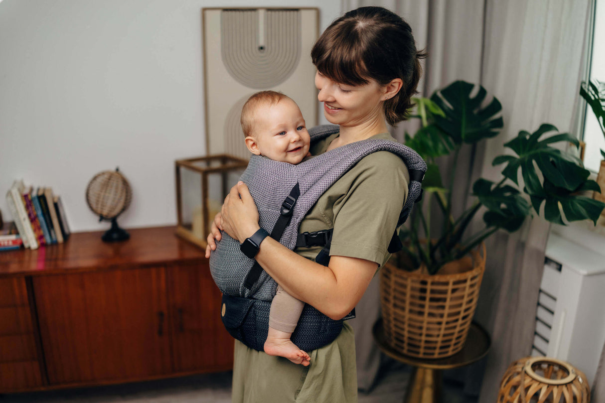 Mom smiling with baby in LennyLamb LennyLight - Little Herringbone Ombre Grey carrier, showcasing comfort and versatility | Babymaxi