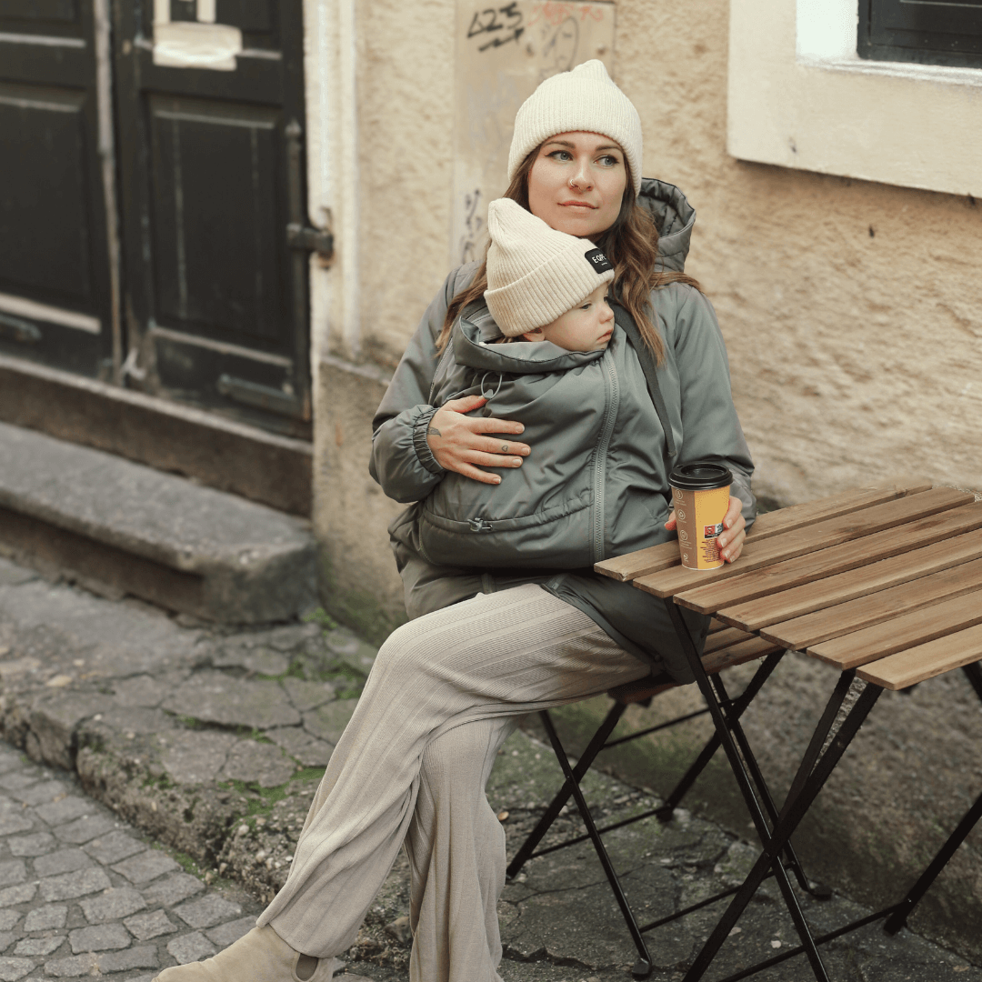 Mamalila Boston Babywearing Jacket - Agave worn by mother carrying baby, stylish and practical for motherhood | Babymaxi