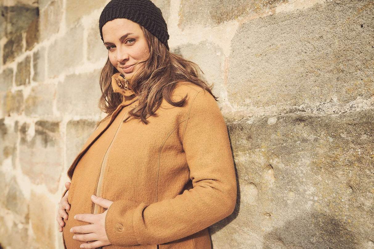 Mamalila Eco Wool Babywearing Coat Oslo - Camel worn by a pregnant woman in an urban setting | Babymaxi