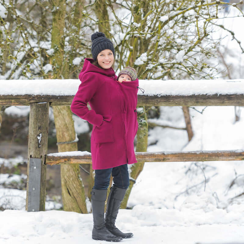 Mamalila Hooded Babywearing Coat Vienna - Berry in snow, featuring a parent and baby, showcasing warmth and style | Babymaxi