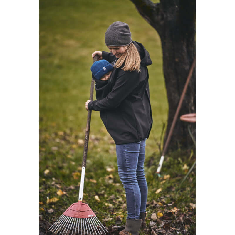 Mamalila Softshell Babywearing Jacket Allrounder - Black in use outdoors, providing comfort and style for mother and child | Babymaxi