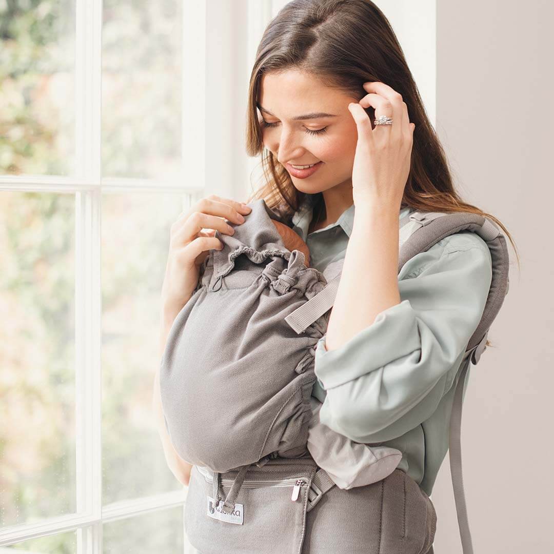 Smiling woman using the Quokkababy E-Carrier - Light Grey, showcasing its comfort and ergonomic design. | Babymaxi