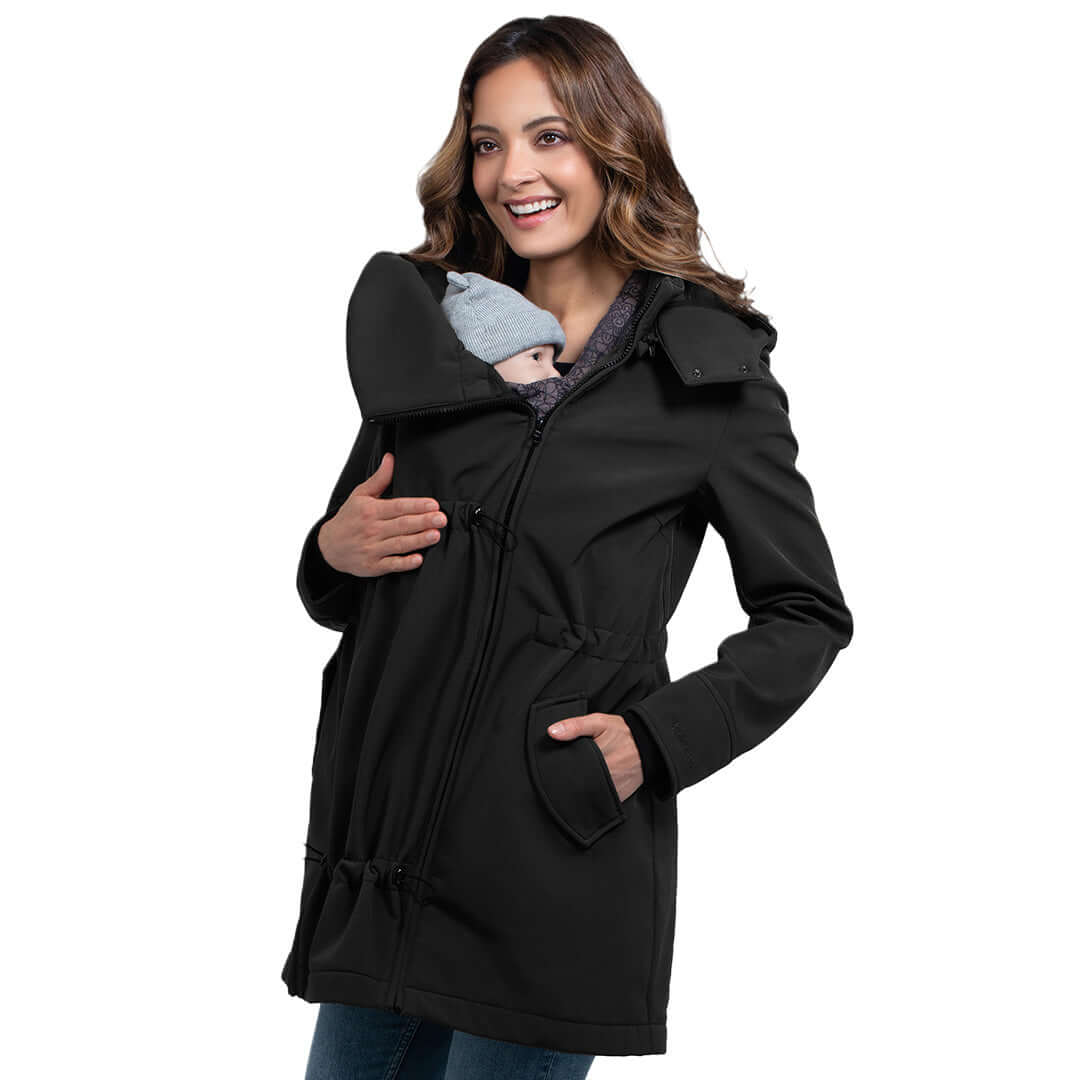 Wombat & Co. London - Shell Baby Carrier Coat - Black worn by a smiling woman with a baby, versatile winter jacket for babywearing | Babymaxi