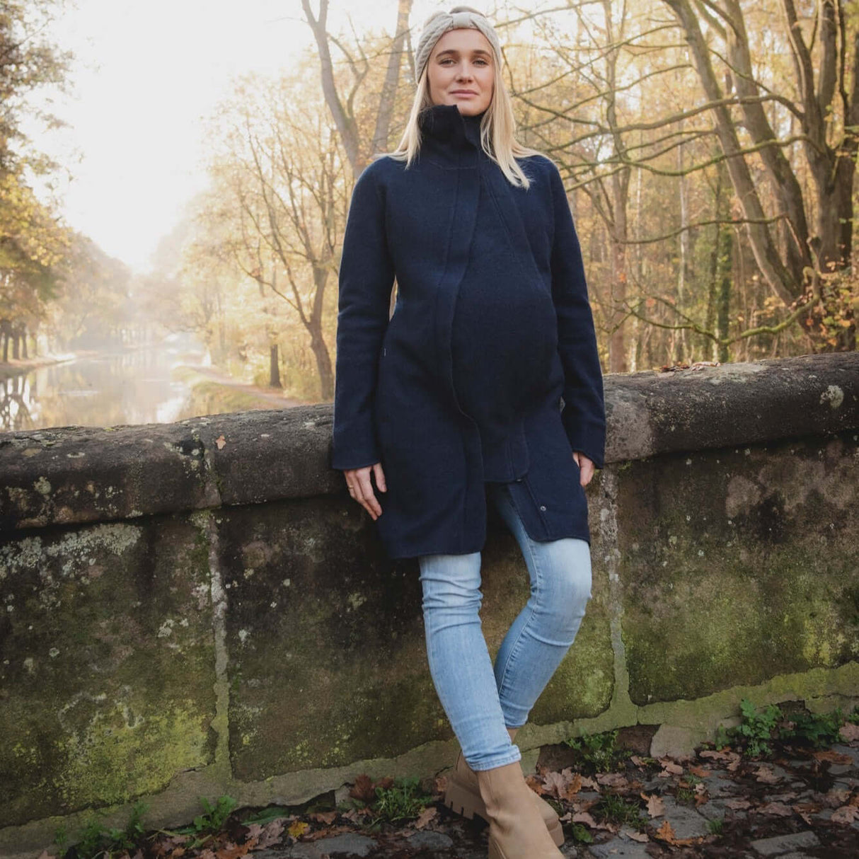 Mamalila Eco Wool Babywearing Coat Oslo - Navy on a pregnant woman outdoors with nature in the background | Babymaxi