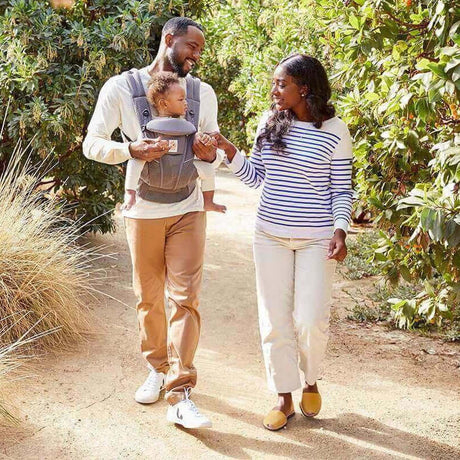 Parents using Ergobaby Omni Breeze - Graphite Grey baby carrier during a family walk | Babymaxi