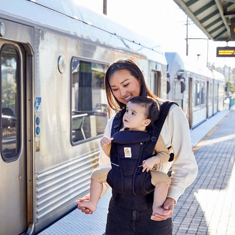 Mom using Ergobaby Omni Breeze - Onyx Black baby carrier while waiting at the train station | Babymaxi