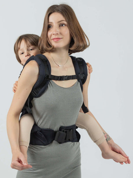 Isara The One - Noire ergonomic baby carrier with a child on the back of a parent | Babymaxi