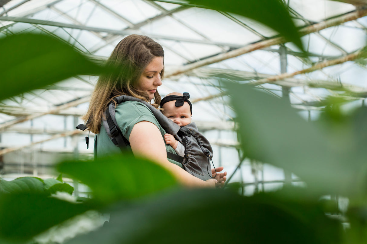 Woman holding a baby in a Neko carrier 