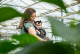 Woman holding a baby in a Neko carrier 