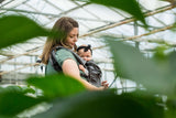 Neko Switch Baby Carrier - Bold, 2 extra hoods being used in a greenhouse with a parent and baby | Babymaxi