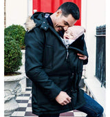 Father wearing Wombat & Co. London - Bandicoot Baby Carrier Coat for Men - Black, holding baby in front pouch | Babymaxi