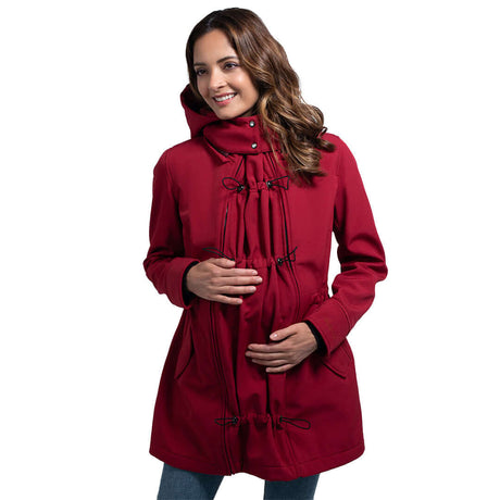 Wombat & Co. London - Shell Babywearing Coat - Cherry Red worn by a smiling woman, showcasing its stylish design and babywearing features | Babymaxi